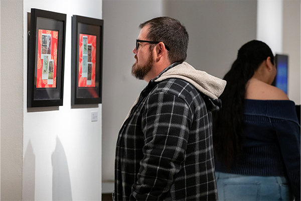 Exhibit attendee is immersed in the artwork at the “Echoes of Identity” exhibit.