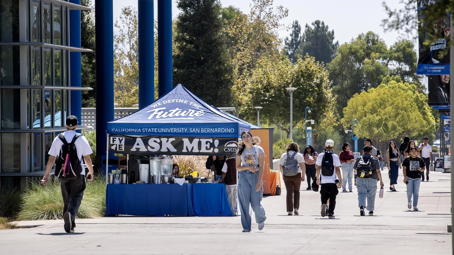 Students on Coyote Walk pass an "Ask Me!" table on Aug. 26, the first day of the 2024 fall semester.