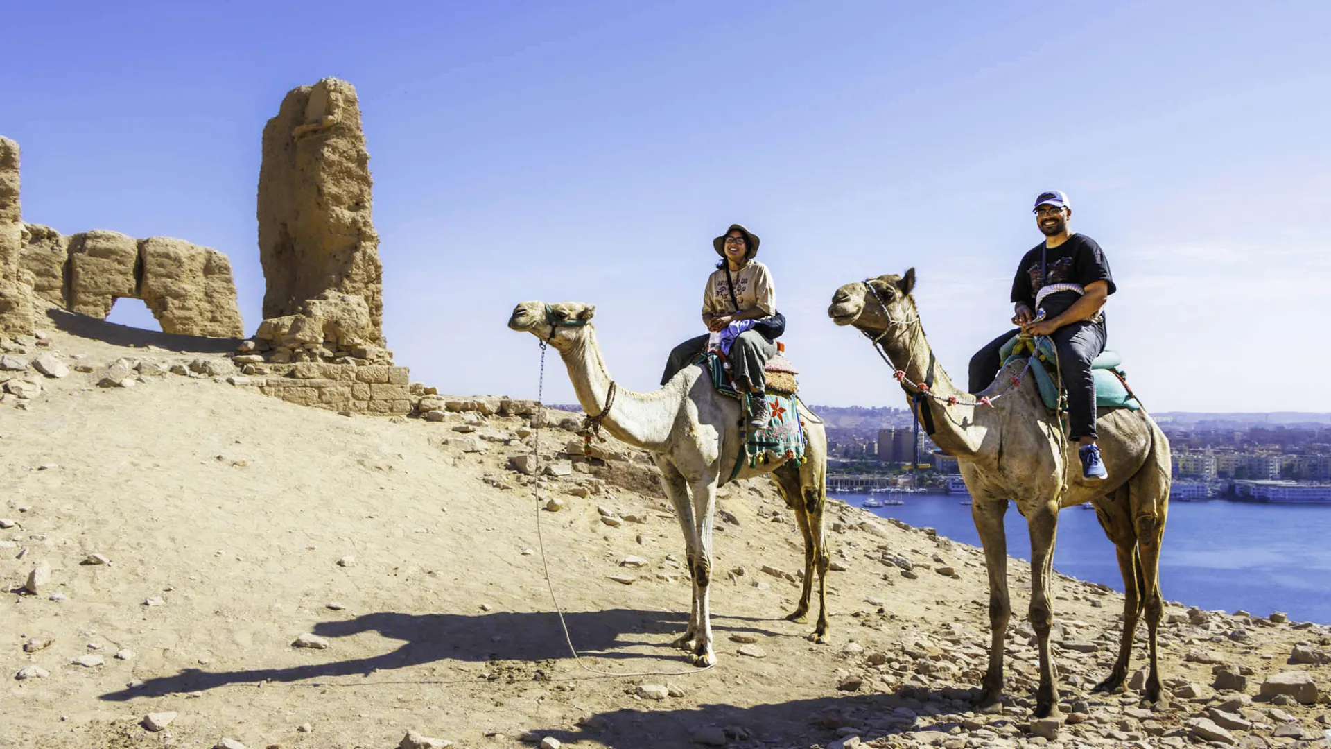 Nathaniel Saavedra, at right, with another person, both on camels in Egypt.