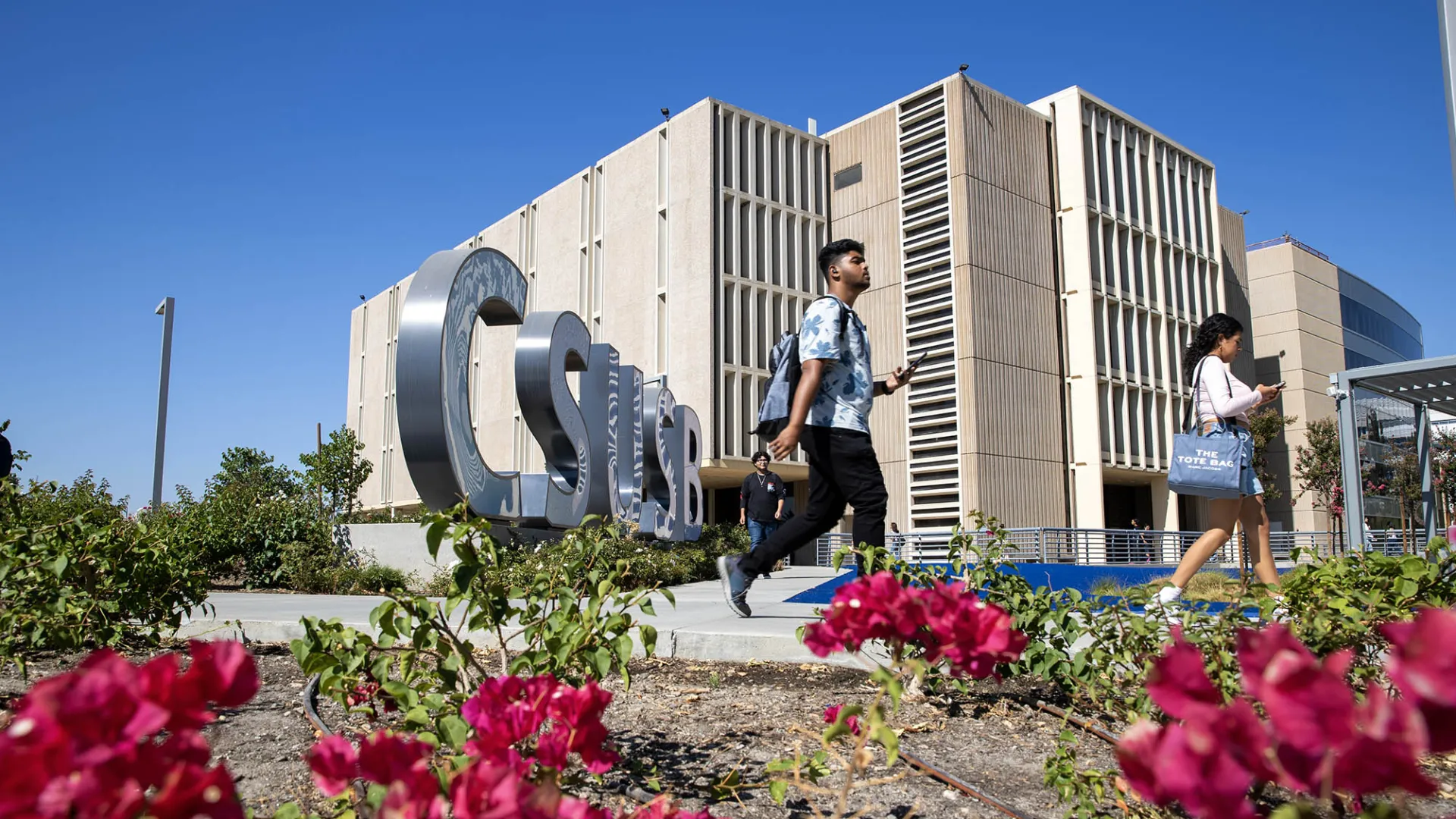 Students make their way past the John M. Pfau Library. U.S. News & World Report has again recognized CSUSB’s graduate criminal justice and MBA online programs as among the best in the nation.