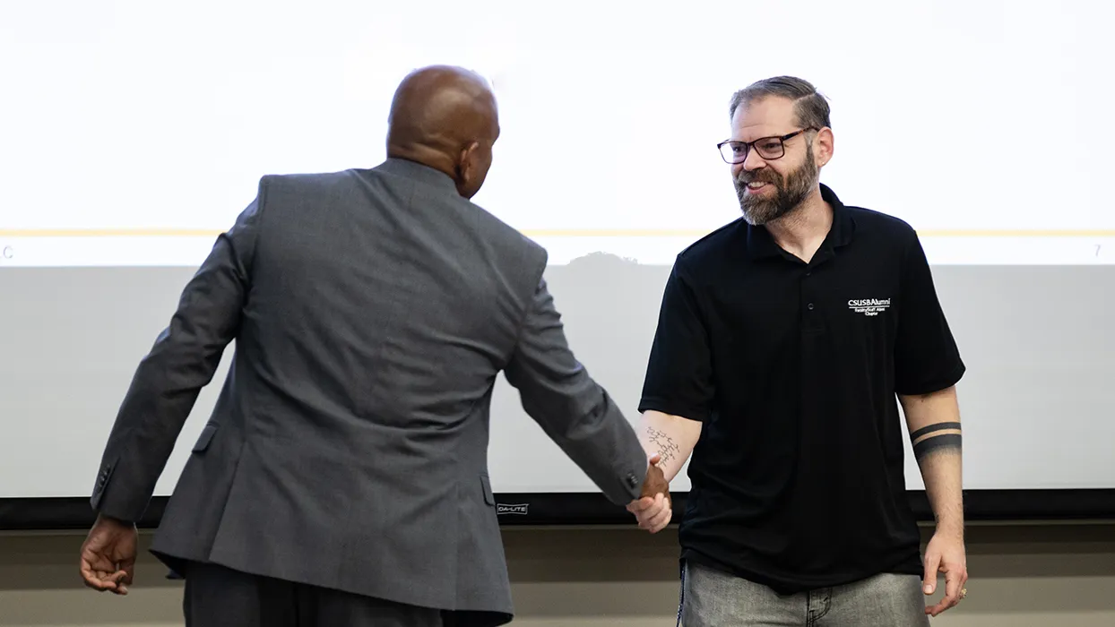 Provost Rafik Mohamed, left, presented the 2025-26 Golden Apple Award to Nathaniel Bodell, associate professor of kinesiology.
