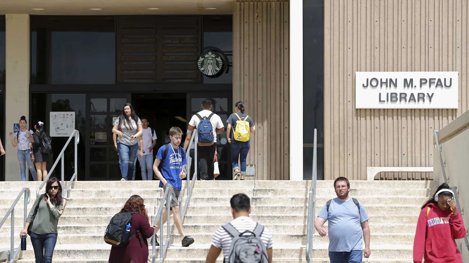 Students at the front entrance of CSUSB’s John M. Pfau Library