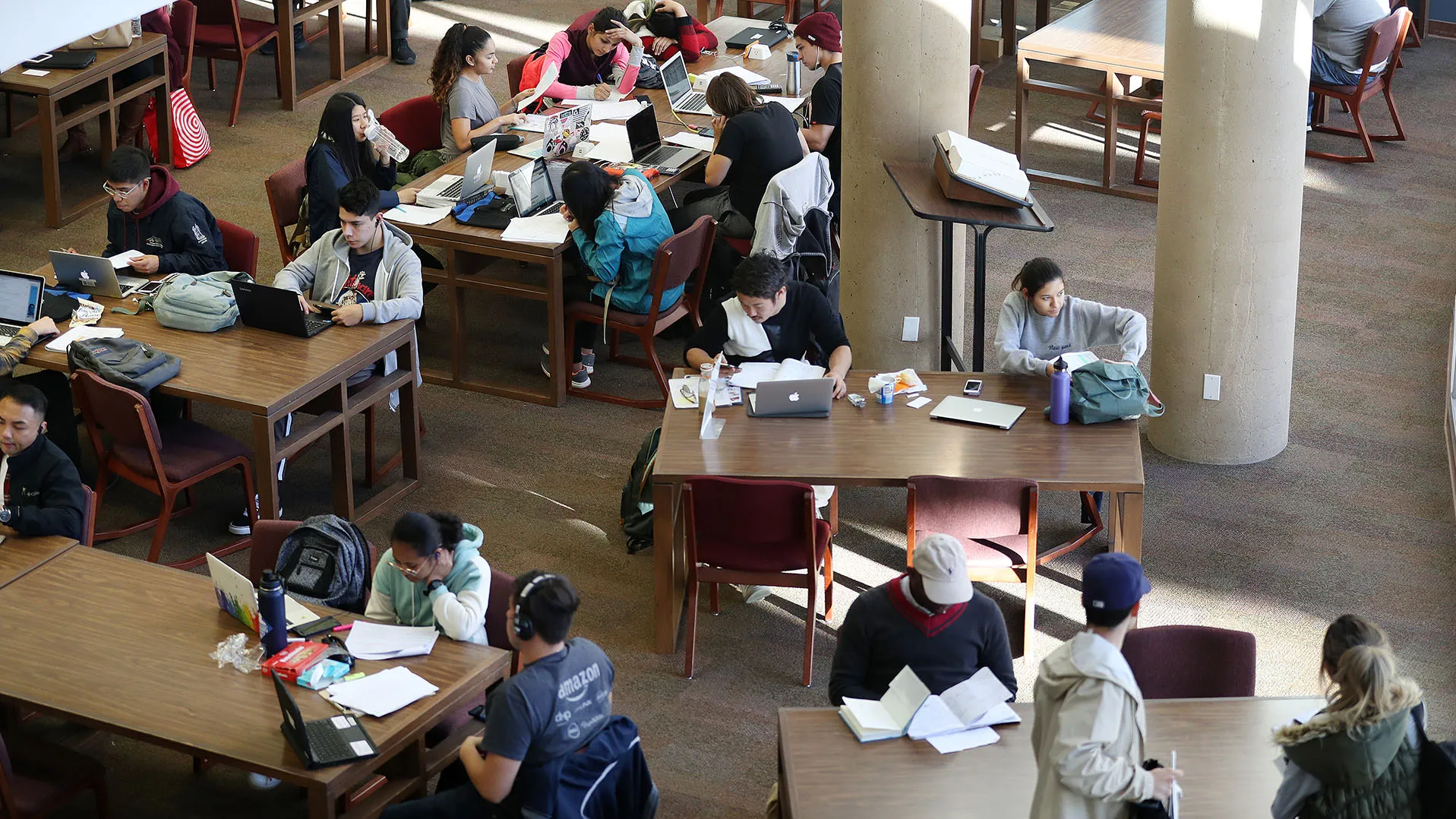 Students at CSUSB’s John M. Pfau Library, first floor study area. 