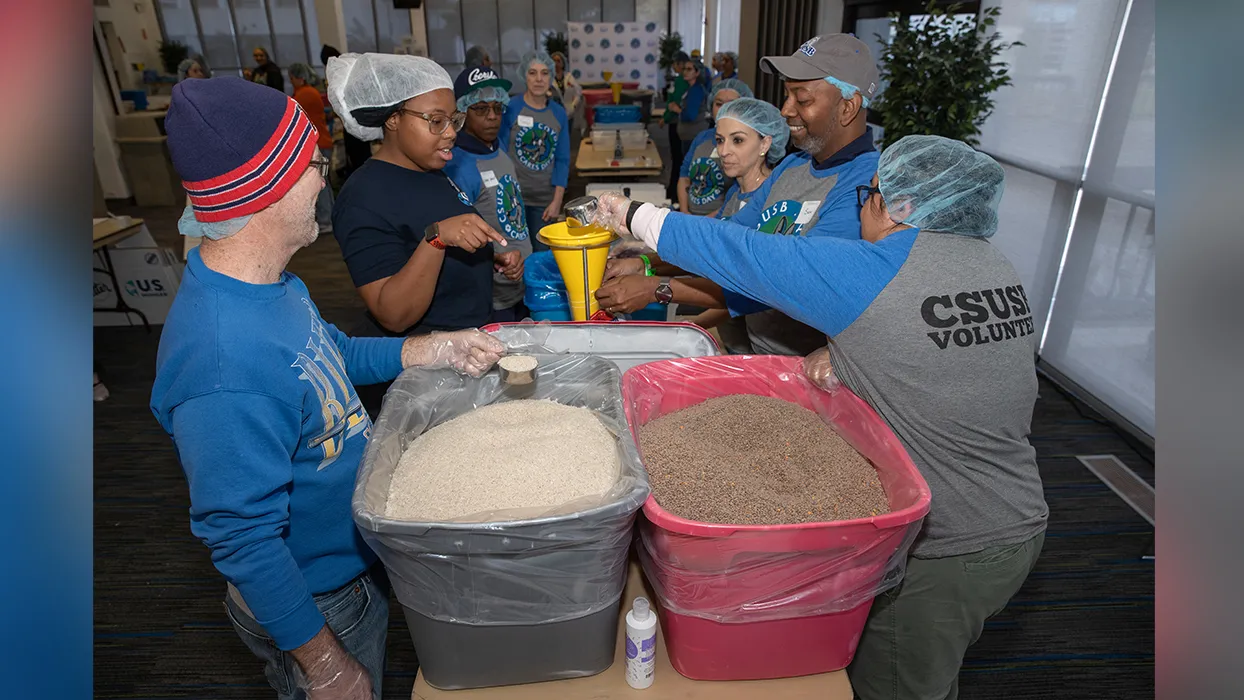 CSUSB alumni and staff Coyote Cares Day volunteers prepare ingredients for jambalaya soup mix. 