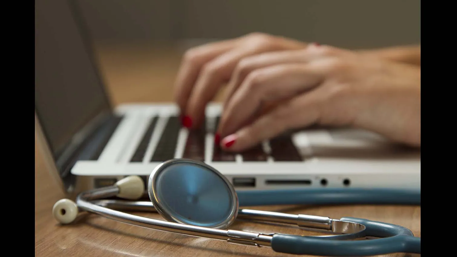 Illustration of a medical professional and a laptop computer.