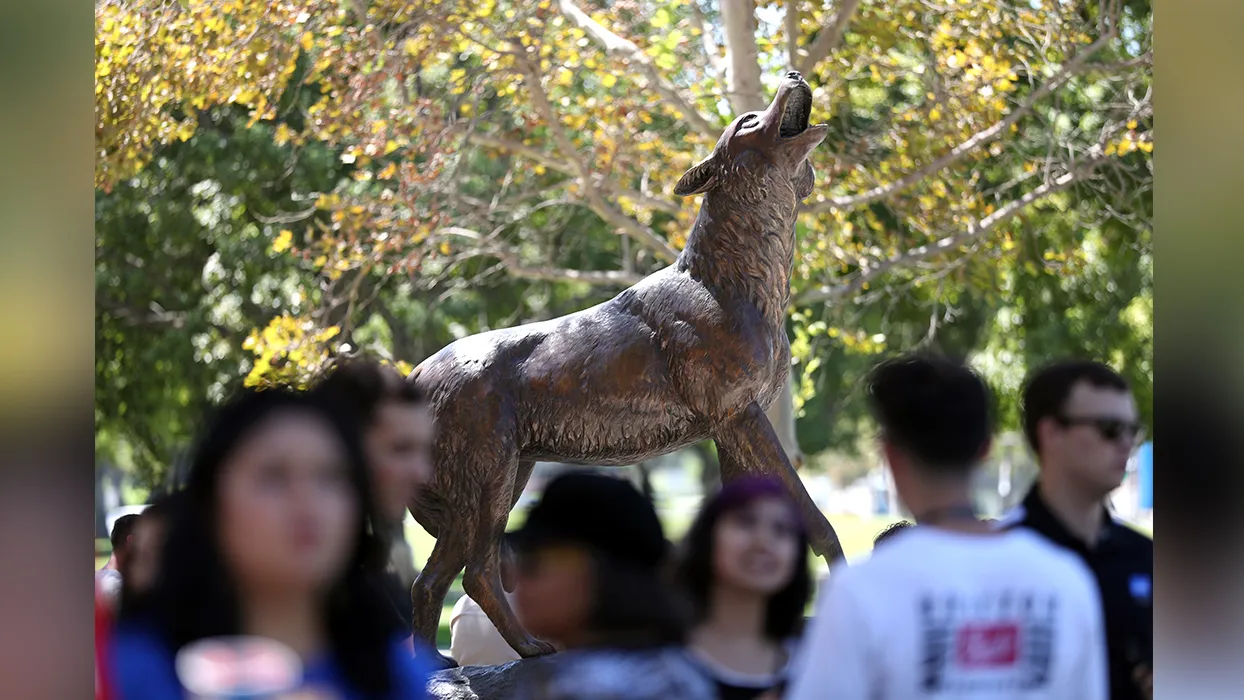 Students surrounding CSUSB’s Wild Song statue 