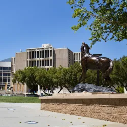 The Wild Song statue on the CSUSB campus with the John M. Pfau Library in the background.