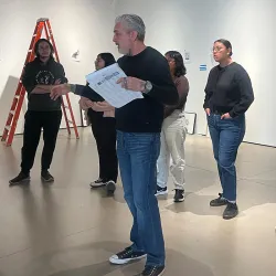 The Robert and Frances Fullerton Museum of Art staff and students discuss an exhibit in the museum gallery.