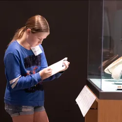 A participant of the Kids Discover Egypt Workshop examines an art exhibit at RAFFMA.