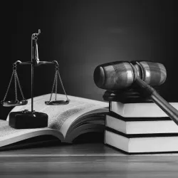 Black and white photo of a scale, books and gavel to symbolize criminal justice