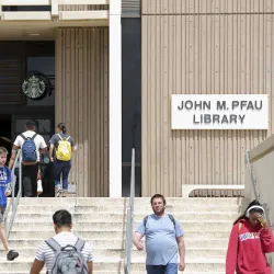 Students at the front entrance of CSUSB’s John M. Pfau Library