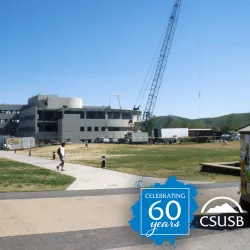 A crane stretches over the construction of University Hall in the 1990s, a decade of continuing growth on the Cal State San Bernardino campus.