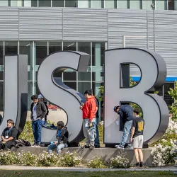 Students hanging by the CSUSB letters