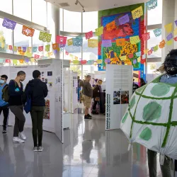 Visitors make their way through the Afróntalo exhibition at CSUSB’s Anthropology Museum. Rising up on the wall is the two-story mural painted by Julio “Honter” Antuna Lopez, and to the left is a prop for the Danza de la Tortuga (Dance of the Turtle) from Mexico’s Costa Chica region.