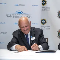 Tomás D. Morales, left, President of California State University, San Bernardino, and Celeste Townsend, President and Chief Executive Officer, California Indian Nations College, sign an MOU at Classic Club in Palm Desert, on Tuesday, October 4, 2022.