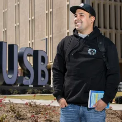 Student by the CSUSB monument sign