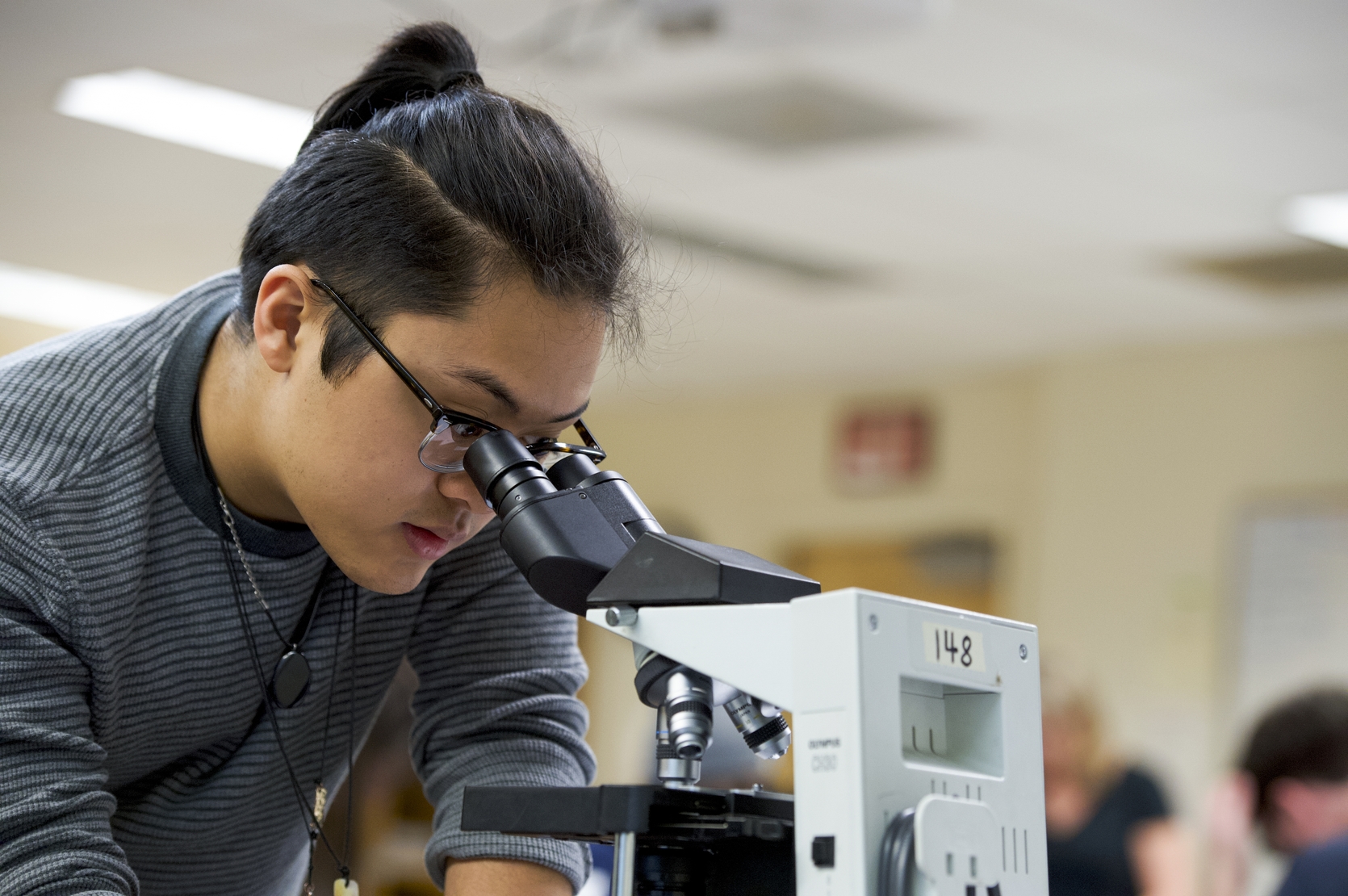 Student looking into microscope