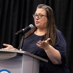 Dr. Molly Springer speaking at a podium