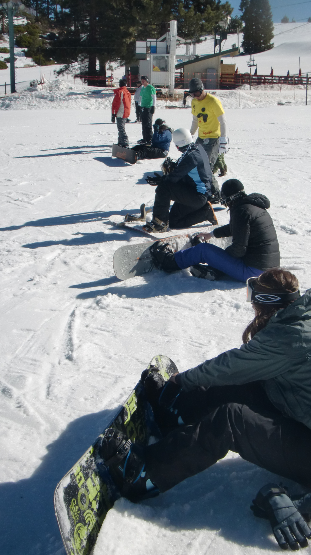 group of students putting on snowboards