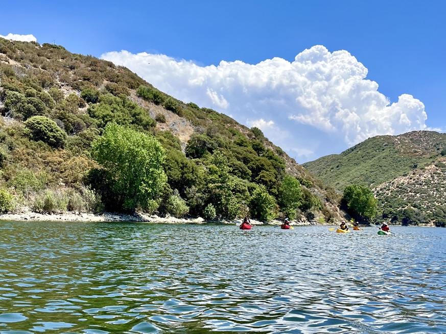 5 kayaks paddling across lake