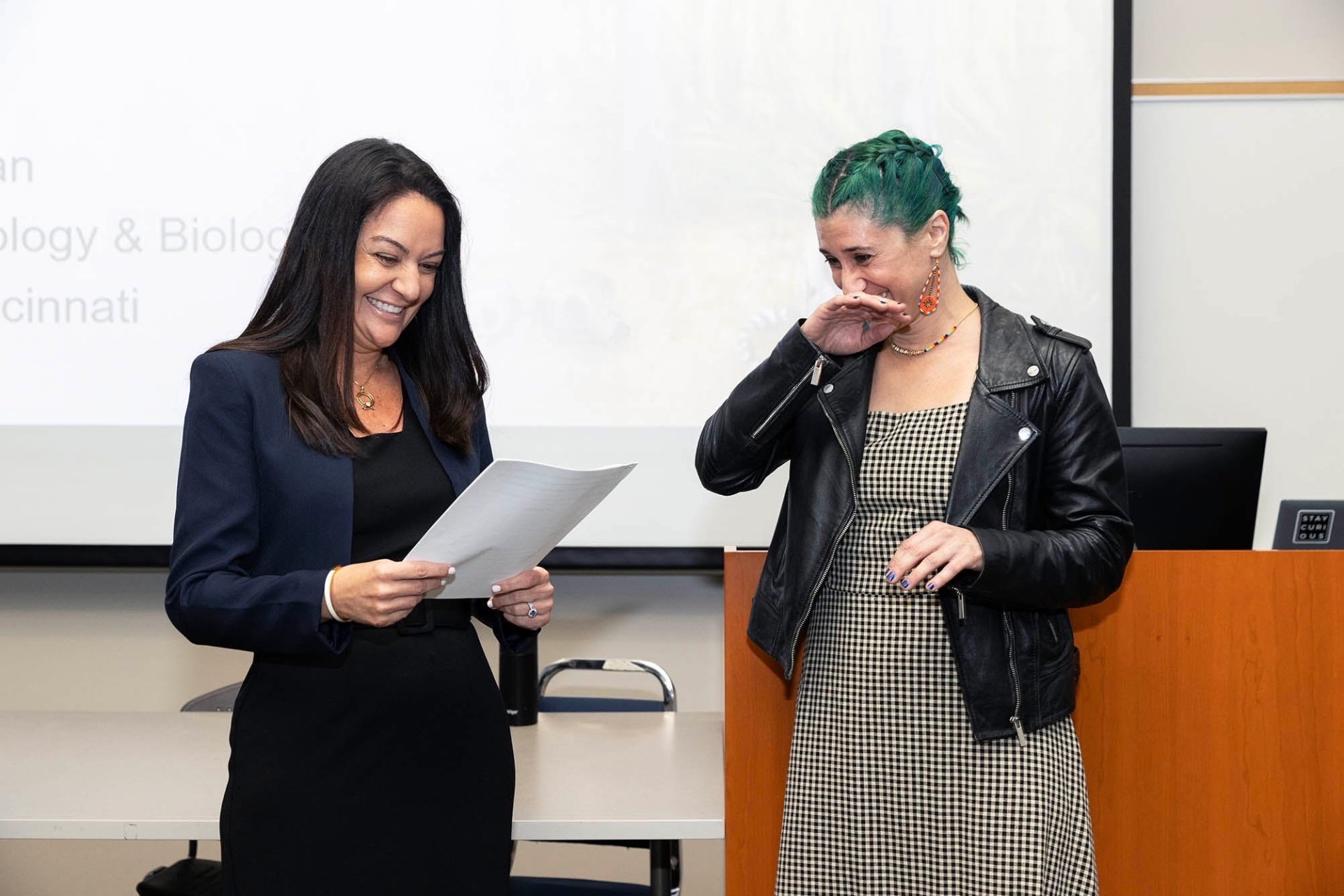 Image of two individuals standing in front of a classroom