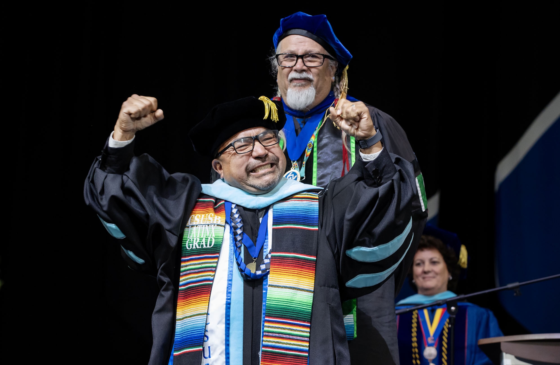 Juan C Luna celebrates after formally receiving his doctoral hood in educational leadership from Enrique Murillo Jr., director of the Doctorate in Educational Leadership program, at the James R. Watson & Judy Rodriguez Watson College of Education and College of Arts and Letters commencement at Toyota Arena in Ontario, CA on Saturday, May 17.