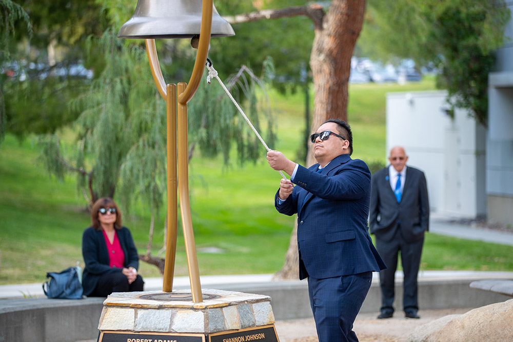 Michael Nguyen, former College of Natural Sciences faculty member, rang the bell 14 times during the Day of Remembrance ceremony to honor each of the fallen victims.