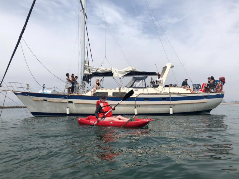 sail boat still with kayaker in boat in front