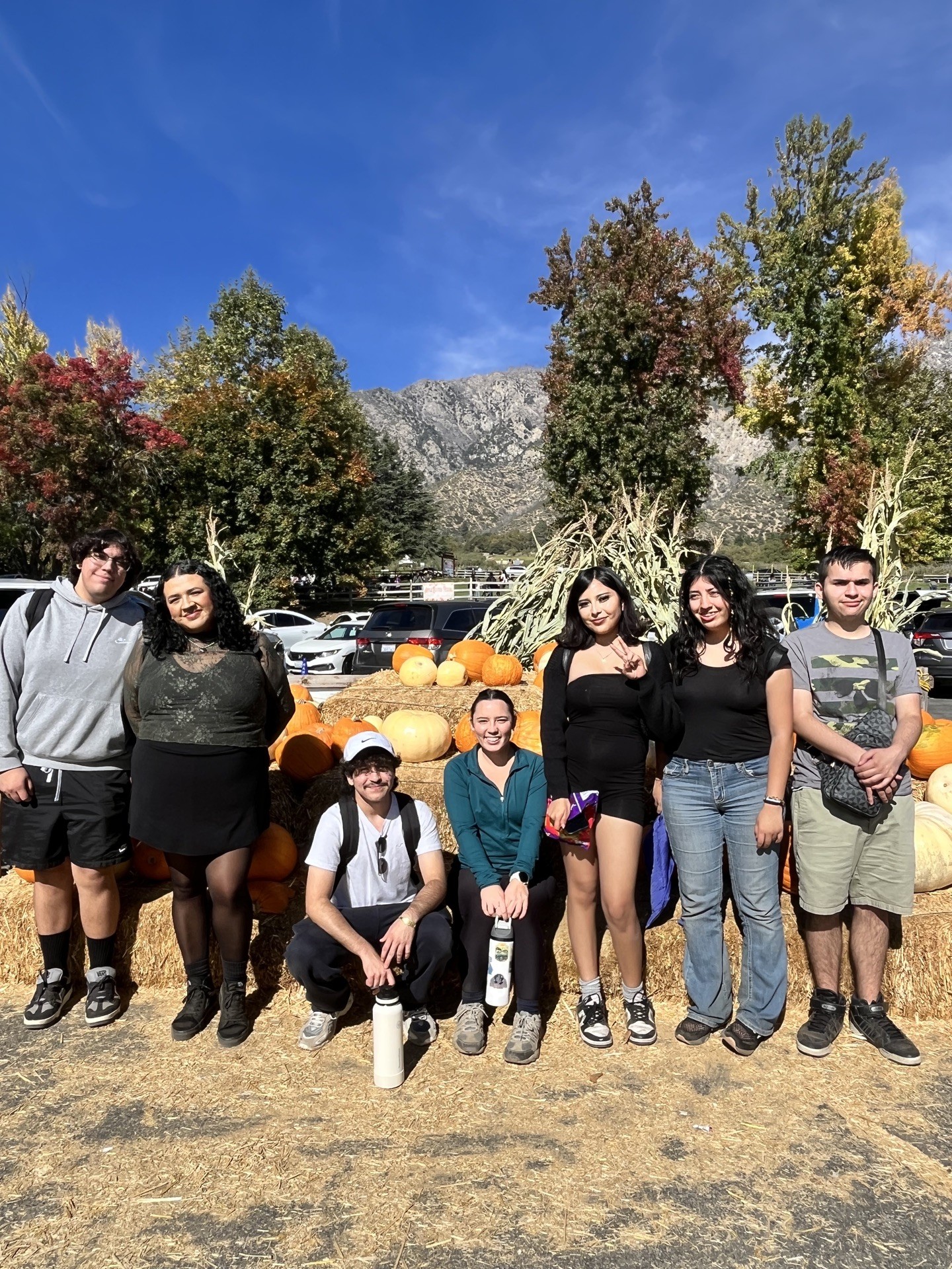 group on hay bails with pumpkins