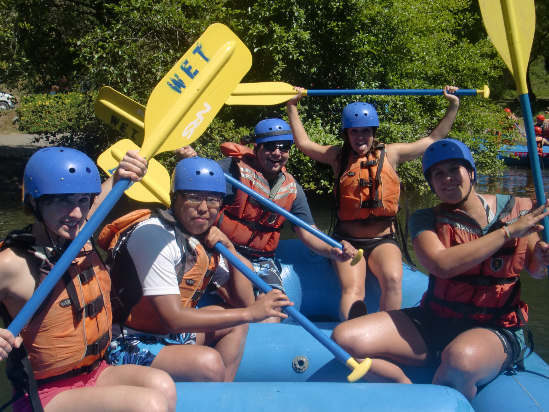 group in boat with paddle raised