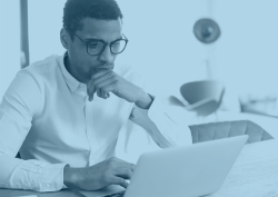 An employee reading his laptop computer screen.