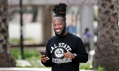 Student standing and holding phone