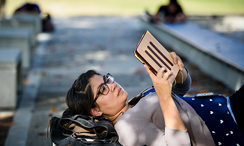 Student laying down reading a book