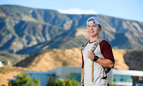 student standing in front of beautiful mountains